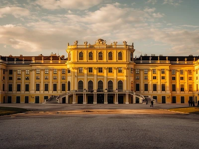 Schönbrunn Palace in Vienna at golden hour, the Maria-Theresia-yellow Baroque facade with formal forecourt